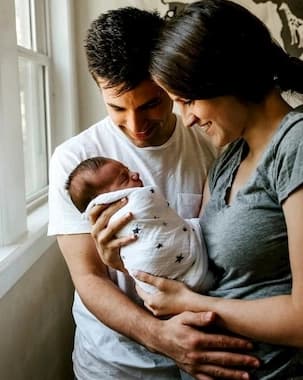 Couple holding their baby born through surrogacy