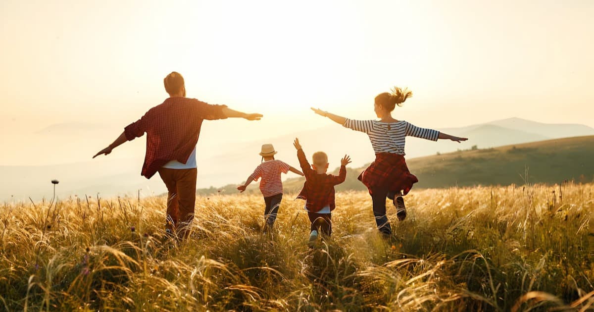 Intended parents celebrating outdoors with their children after finding a private surrogate