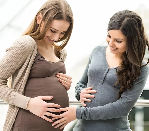 Intended mother and surrogate celebrating pregnancy confirmation