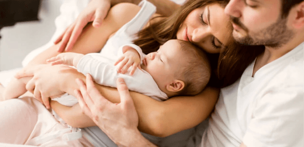 Happy family holding baby born through independent surrogacy in the U.S.
