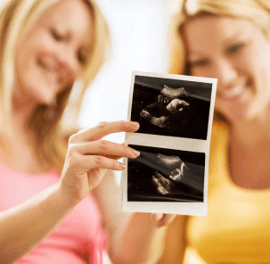 Surrogate and intended mother viewing ultrasound during shared pregnancy moment in Canada